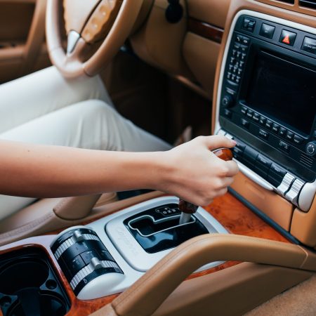 close up of woman shifting gears on gearbox in car